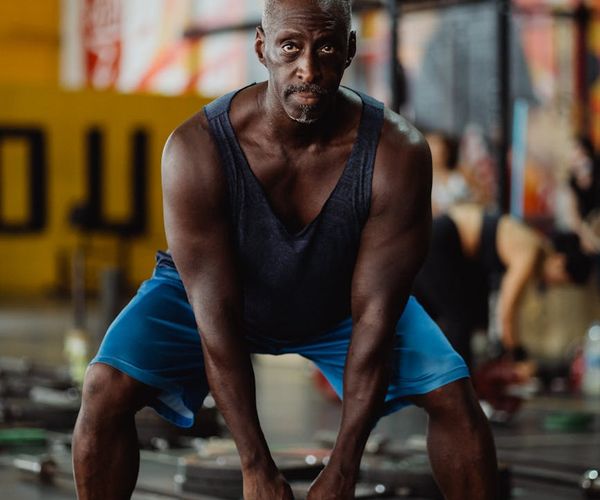 Focused man holding a kettlebell, showing concentration and form.
